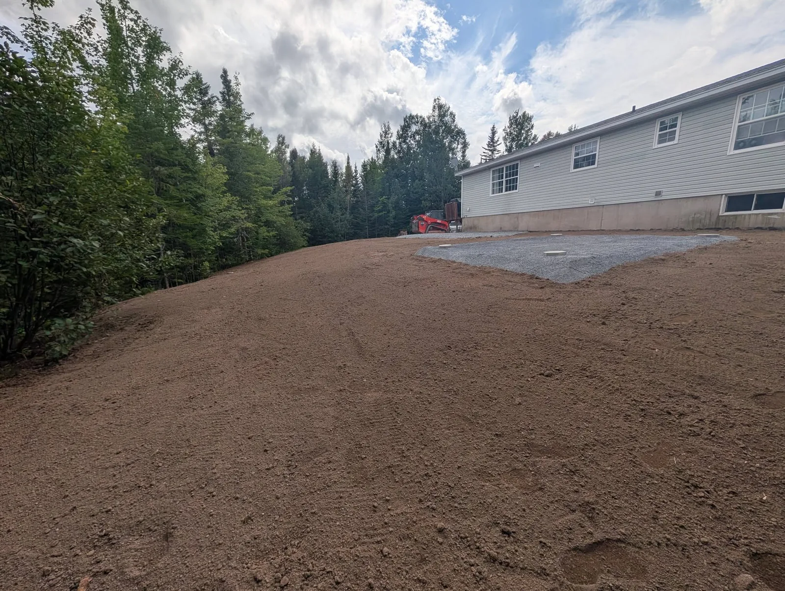 Prepared gravel pad and regraded backyard with fresh topsoil