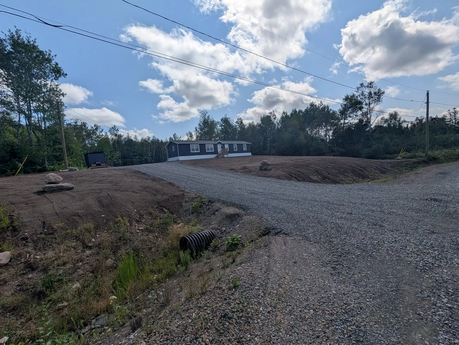 Regraded property and reshaped roadside ditch with a fresh soil finish