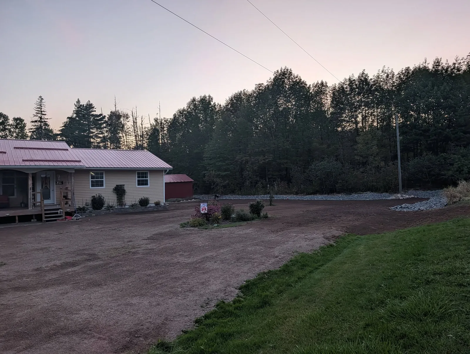 Regraded lawn area and rock-lined drainage channel around the yellow house